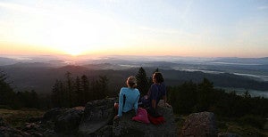 Two people sitting on the top of Spencer Butte overlooking the Willamette Valley