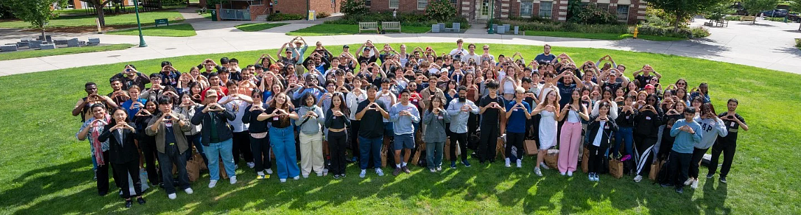 International students making the O sign on the lawn