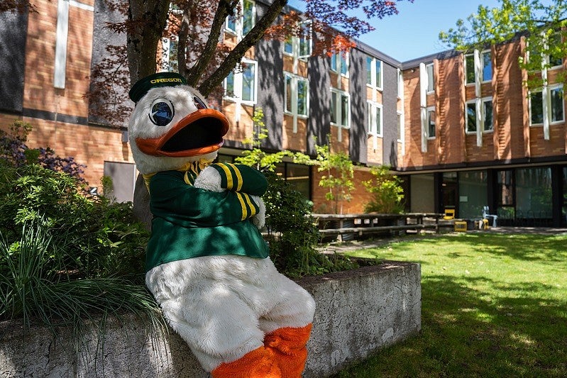 uo duck mascot sitting in front of a residence hall