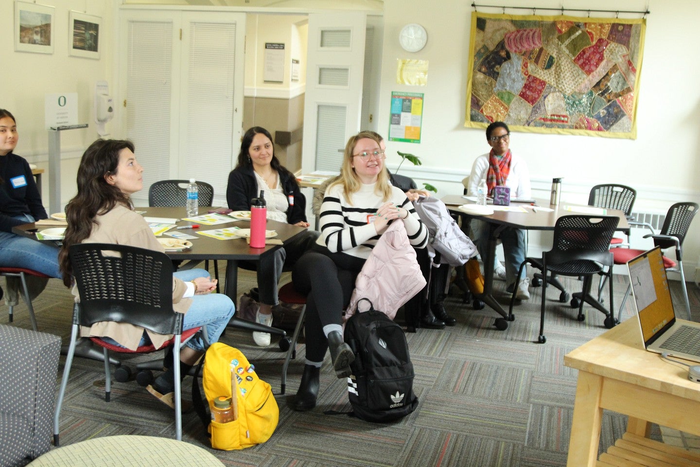 A group of graduate students listening to a speaker 