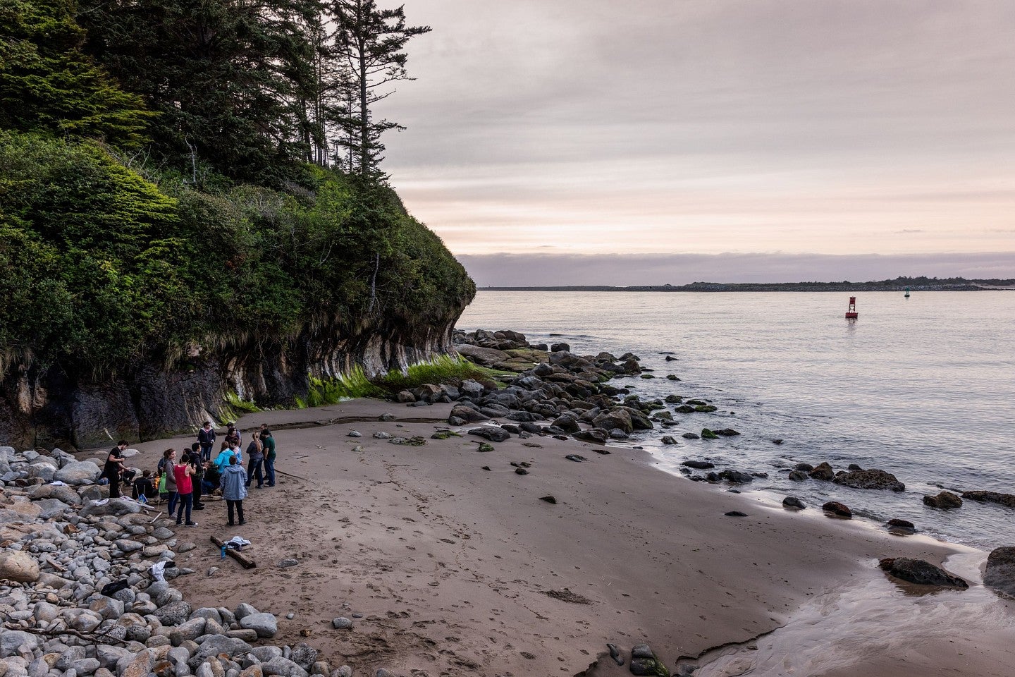 group of people standing on beach at oregon coast