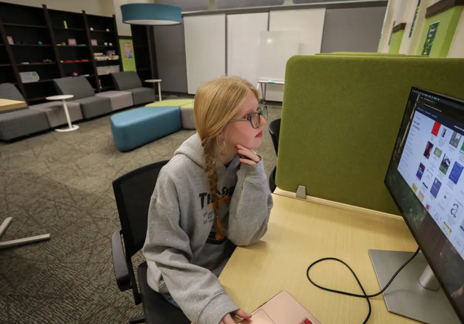 Graduate student studying in front of a computer screen in the GradSpace in Knight Library.