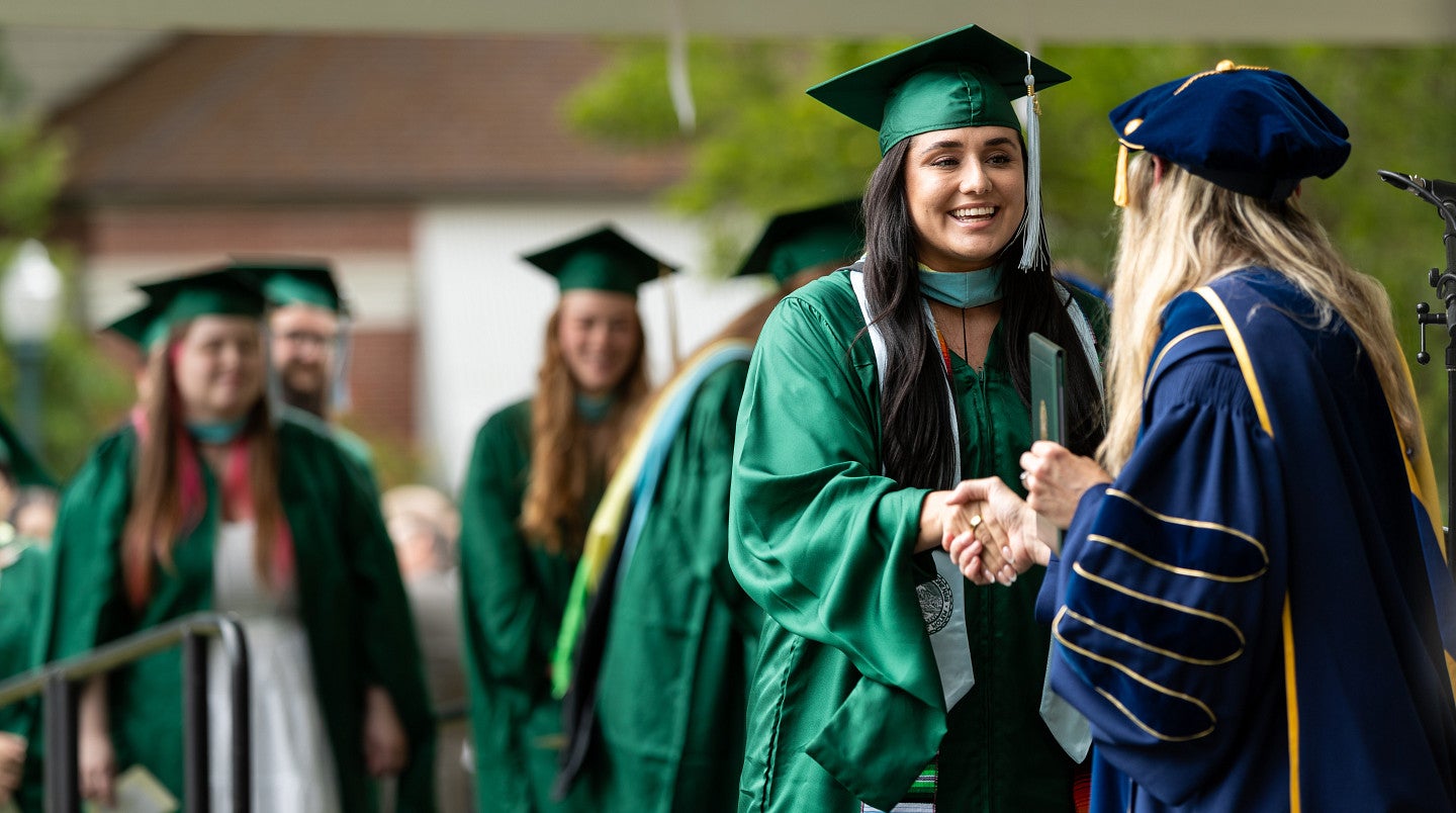 A master's graduate receives their diploma.