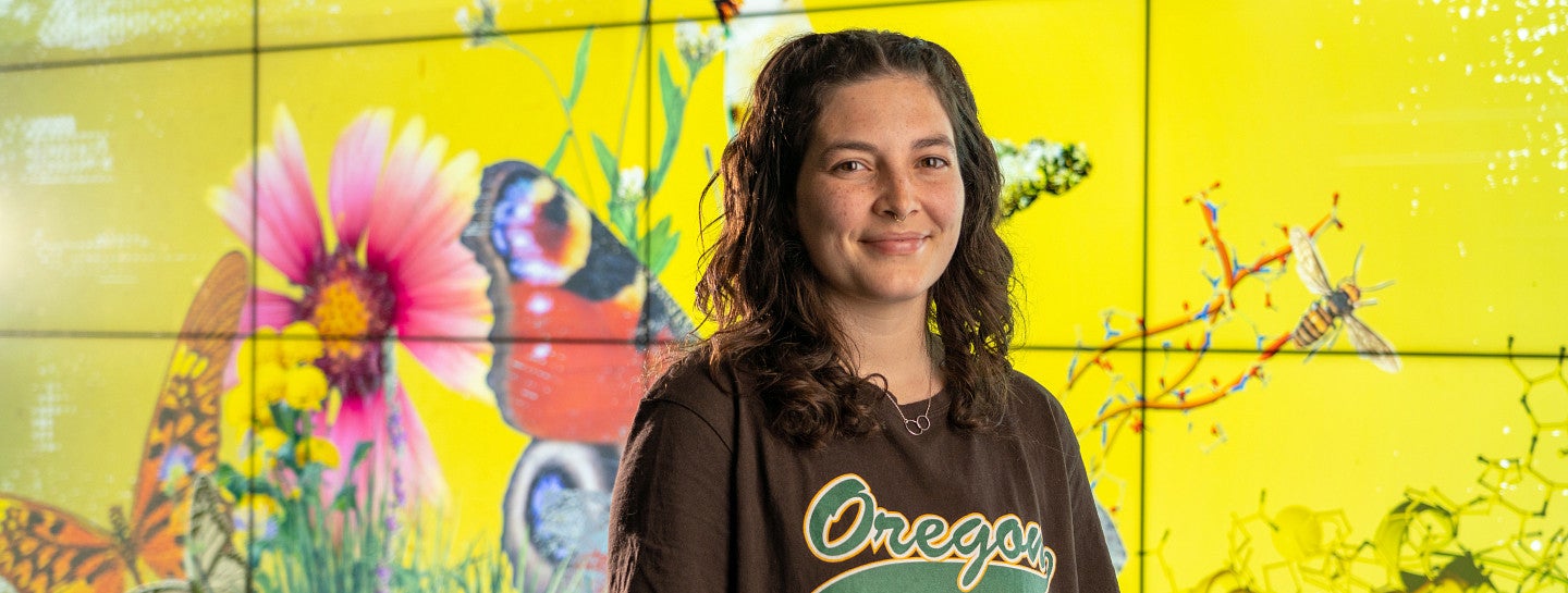 Student standing in front of a vibrant art piece.