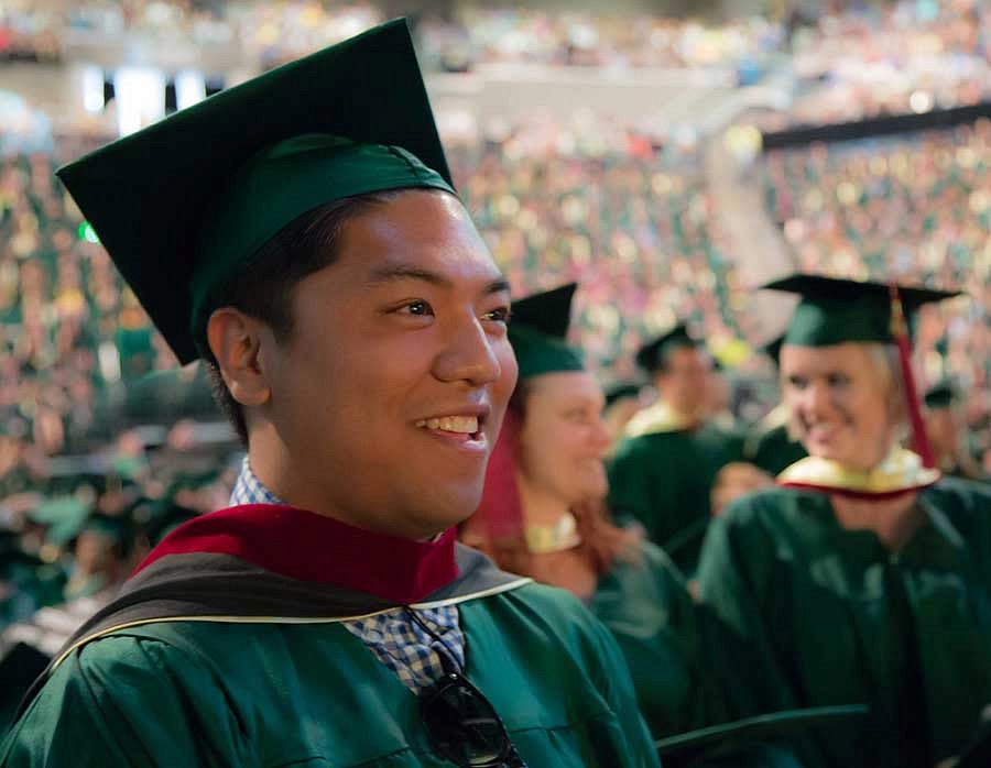 A male master's graduate at commencement A male master's graduate at commencement
