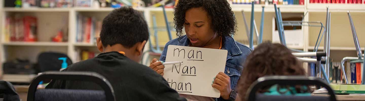 A female teacher working with two students