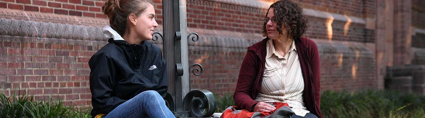 Two students sitting outside the Jordan Schnitzer Museum of Art