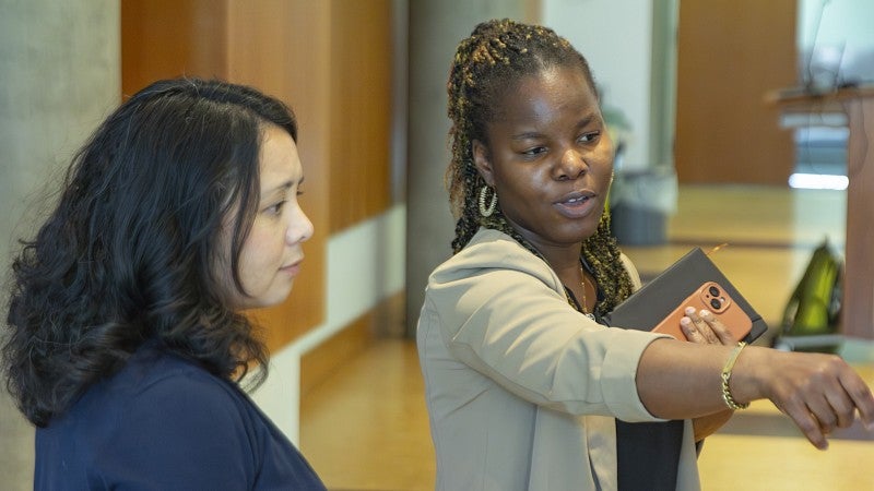 A doctoral student presents a research poster.