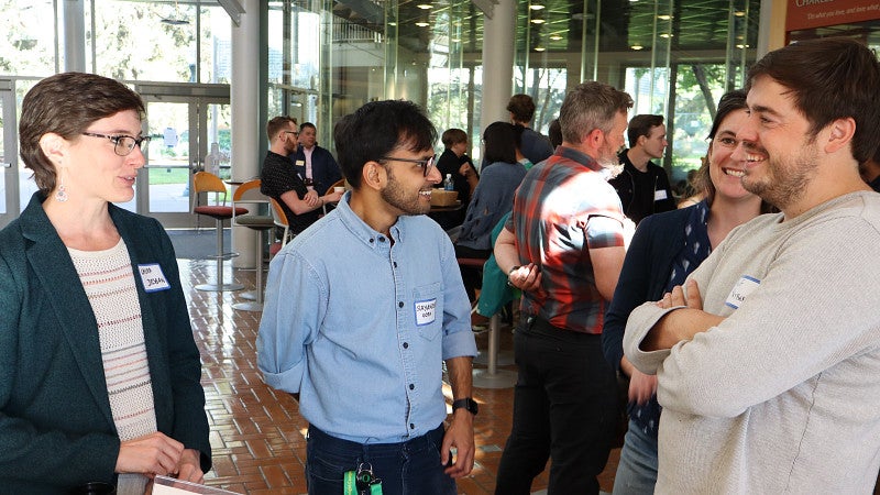 Postdoctoral scholars talking together at a research event.