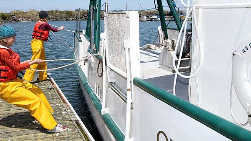 Two students securing the OIMB boat at the dock