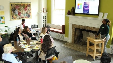 A graduate student giving a presentation in front of a group of graduate students