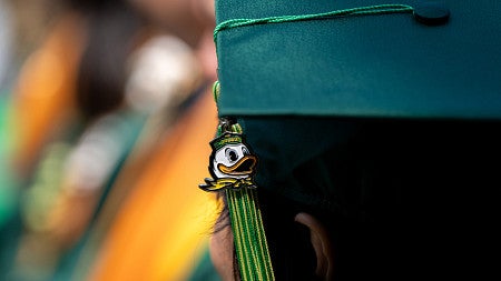 Green graduation cap with a tassel featuring the Oregon Duck.