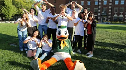 UO international students gathering around Oregon Duck