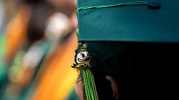 Green graduation cap with a tassel featuring the Oregon Duck.