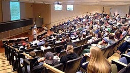 A teaching leading a large class in an auditorium