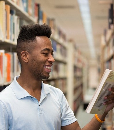 student smiles at book