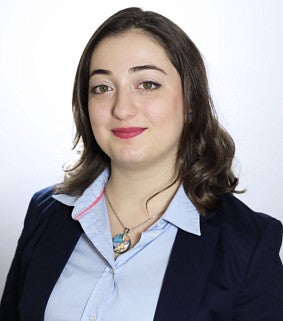 Nina Kankanyan has brown hair and is wearing a blue button down with pink lipstick.