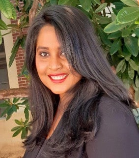 Shahinur Bashar has long dark hair and is wearing red lipstick.