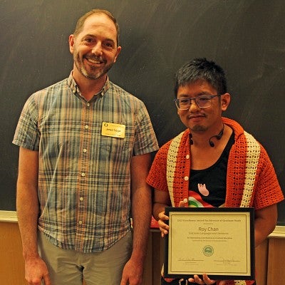 Roy Chan accepts excellence award from Assistant Vice Provost Jered Nagel