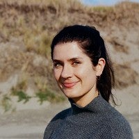 Smiling woman with dark hair in a ponytail.