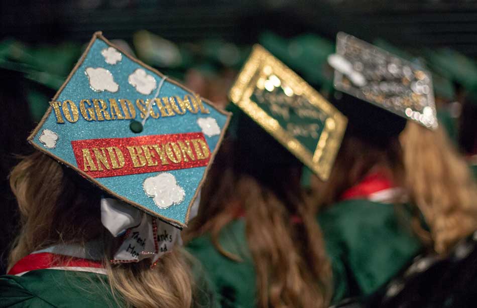 Student at commencement with a mortarboard that says To Grad School and Beyond Student at commencement with a mortarboard that says To Grad School and Beyond